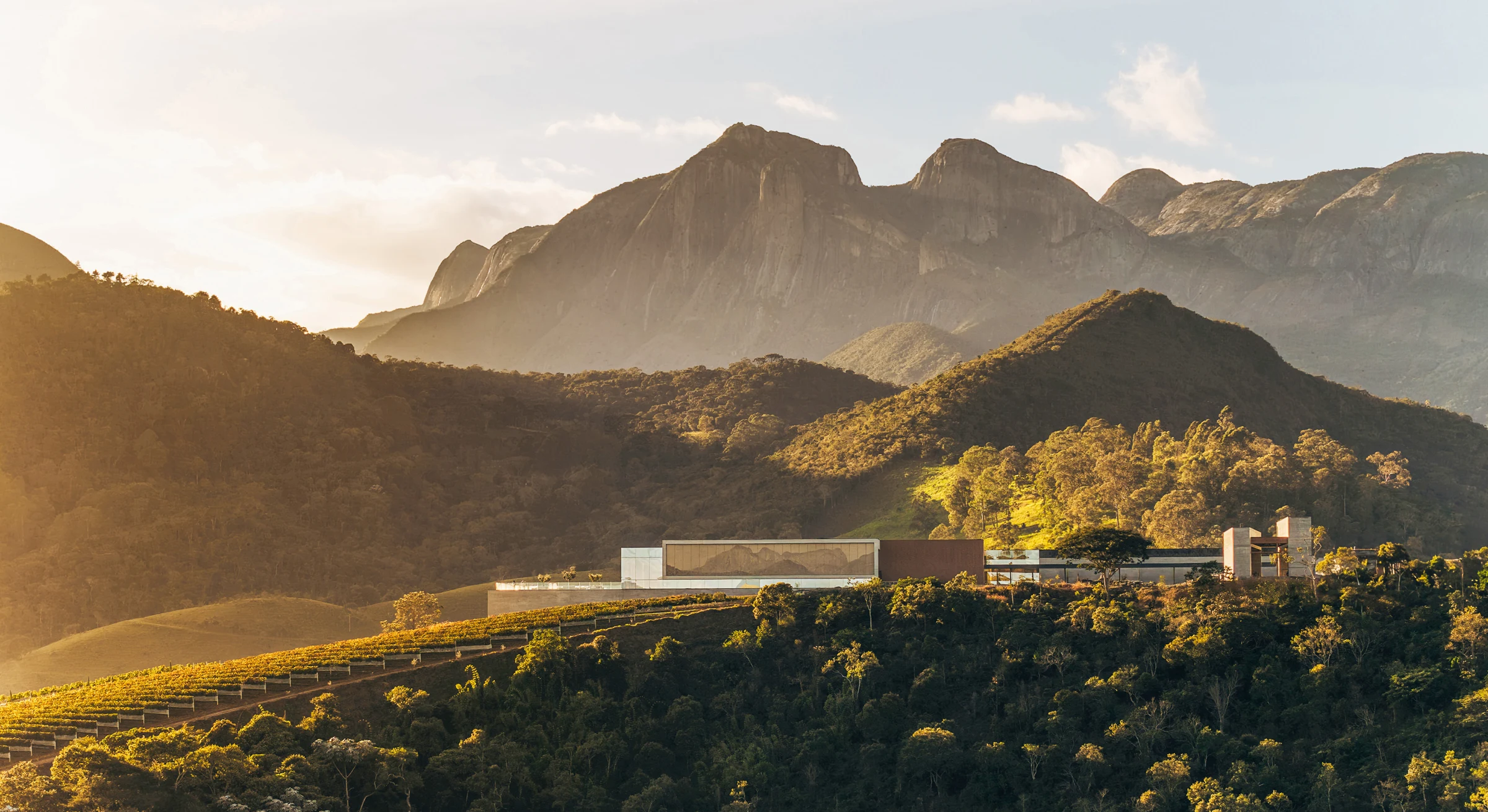 Vinhedos e arquitetura da Vinícola Maturano diante das montanhas de Teresópolis